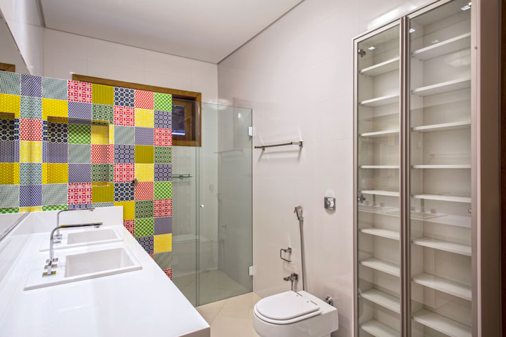 No banheiro, o charme é a parede do box com nicho e patchwork de azulejos (Villa Bella Acabamentos). Luminárias, louças e metais da Jabu Engenharia Elétrica. Puxadores e ferragens da MM Comercial