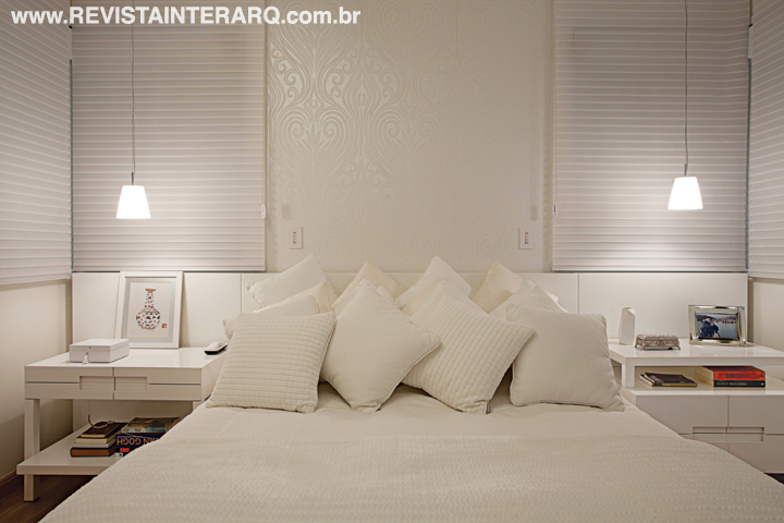 Delicada e relaxante, a suíte segue a proposta clean e apresenta papel de parede, enxoval (Decorações Casarão), móveis sob medida e persiana brancos. 