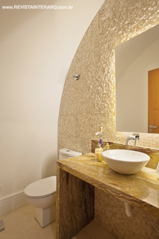O lavabo teve uma das paredes revestida com pastilhas de mármore Travertino, mesmo material utilizado na bancada. 