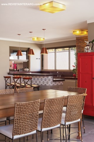 O espaço gourmet tem móveis em fibras e madeira, pendentes cobre (Luzco Iluminação) e bancada em Marrom Absoluto