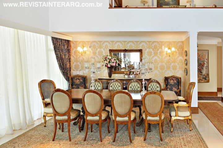 Na sala de jantar, cadeiras medalhão com capitonê em seda acompanham a mesa marchetada com motivos florais e aplicações de bronze