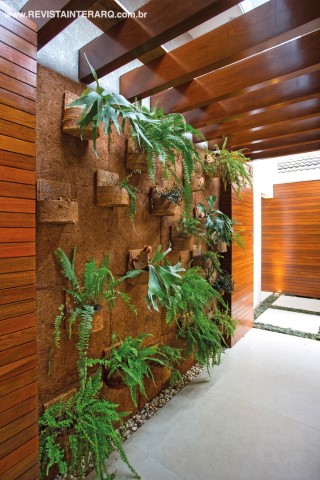 A pérgola de madeira com cobertura translúcida da varanda protege o charmoso jardim vertical (Viverde Garden)
