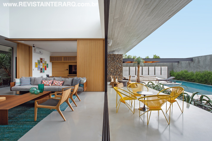 O piso autonivelante cinza une visualmente o living e a varanda, que ganhou móveis mais coloridos e descontraídos