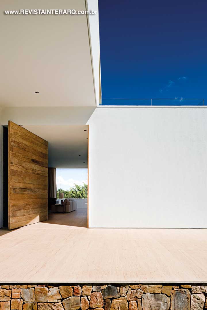 A opção pelo mármore Travertino, aliado ao branco da volumetria, concretiza o modernismo na arquitetura da casa