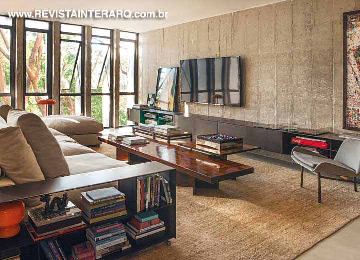 As profissionais recuperaram as esquadrias basculantes de piso ao teto, que integram o verde da copa das árvores ao interior do apartamento. Para compor com essa proposta, a ambientação traz móveis dos anos 60 assinados por designers brasileiros e sofá italiano (Casual Móveis). Tapete da By Side