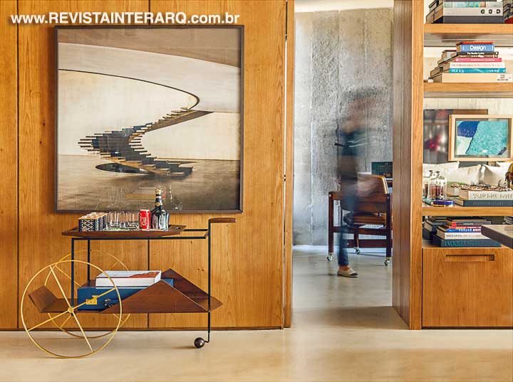 O piso monolítico único em todos os cômodos e os painéis em madeira freijó acentuam a integração visual dos espaços