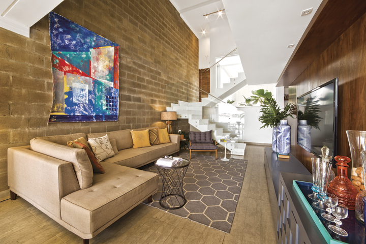O tapete com desenhos geométricos acomoda o sofá em “L”. O projeto arquitetônico da casa é assinado pelo escritório Arruda e Ferrari