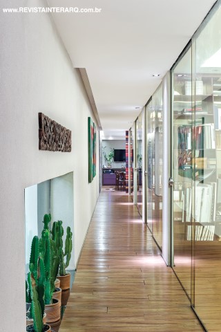 A área de circulação revela a fluidez das divisórias de vidro (Vidro Clean) e a beleza do piso de madeira Hanley (Dom Gabriel)