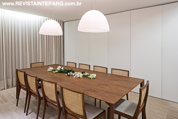 A porta estilo “camarão” setoriza ou integra o jantar, com mesa Dinn de Jader Almeida e cadeiras GB de Geraldo de Barros (tudo da Hill House)