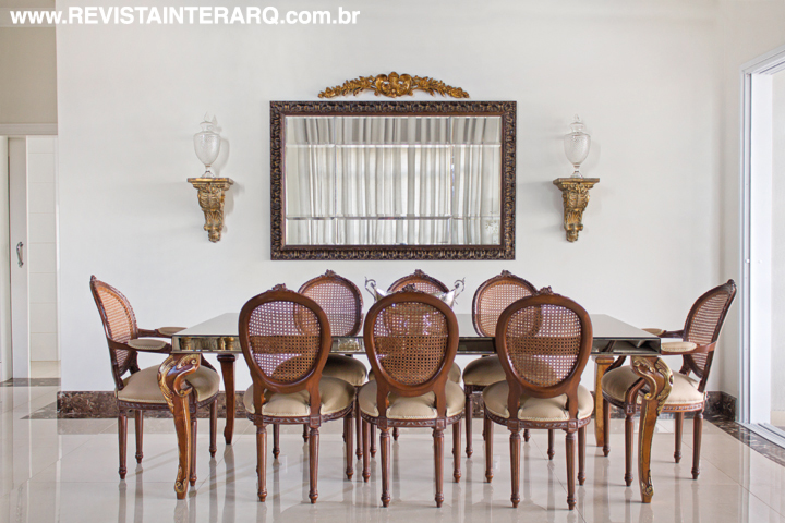 No jantar, mesa e cadeiras Medalhão em madeira e palhinha (Decorativa) convidam a encontros gastronômicos. A peanha na parede, ao lado do espelho, é da Marizza Prado