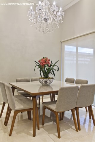 Na sala de almoço, o lustre de cristal (Casa Luz) faz contraponto à contemporaneidade da mesa e cadeiras estofadas com linho cinza. O piso em porcelanato é da Casa dos Construtores