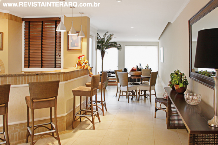 Uma ampla sala, integra diversos ambientes, incluindo o espaço destinado às refeições, que tem mesa de jantar e cadeiras em fibra
