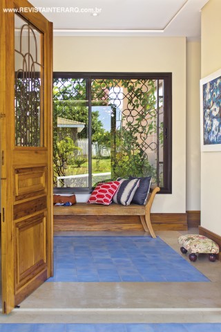 O tapete de ladrilhos hidráulicos azuis (CJÔ Revestimentos) delimita o hall com vista também para o jardim. Esquadrias de alumínio da Projesp