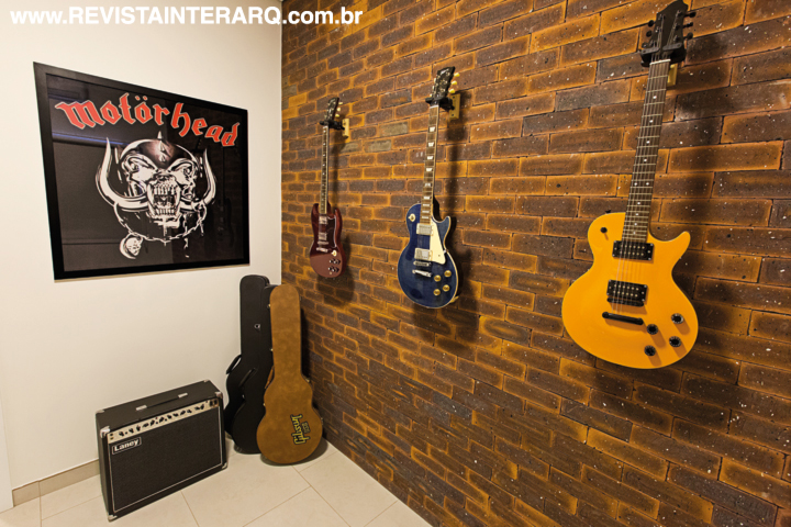 A parede de tijolos Palimanan no office emoldura as guitarras do morador