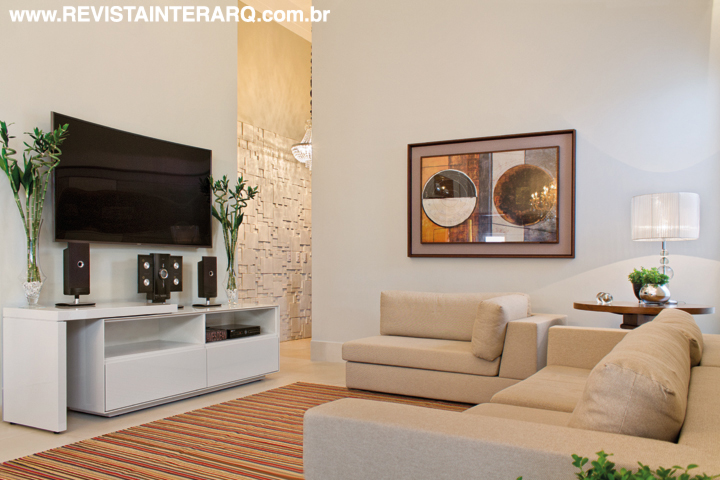 A leveza da ambientação do home, com móvel de TV branco (Roso Móveis), sofás nude (Jackie Móveis) e tapete Kilim by Claudia Queiroz. Todo o sistema de som e áudio é da Home Systems