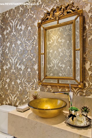 O papel de parede adamascado (Griffe A) acompanha a bancada em mármore Crema Marfil (Marmoraria São Jorge) com cuba dourada