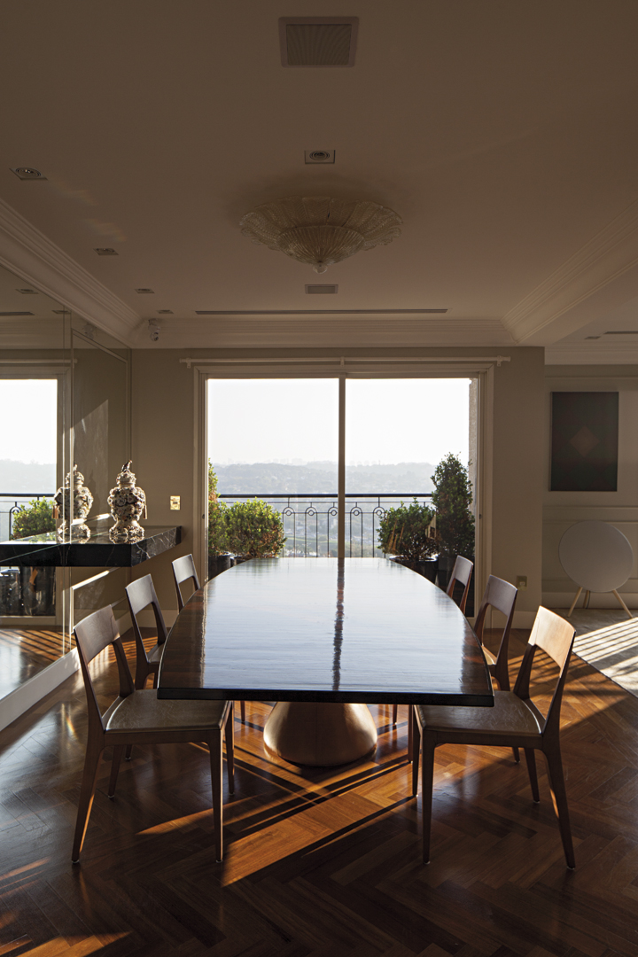 A mesa de jantar assinada por Jader Almeida com o skyline da capital paulista ao fundo