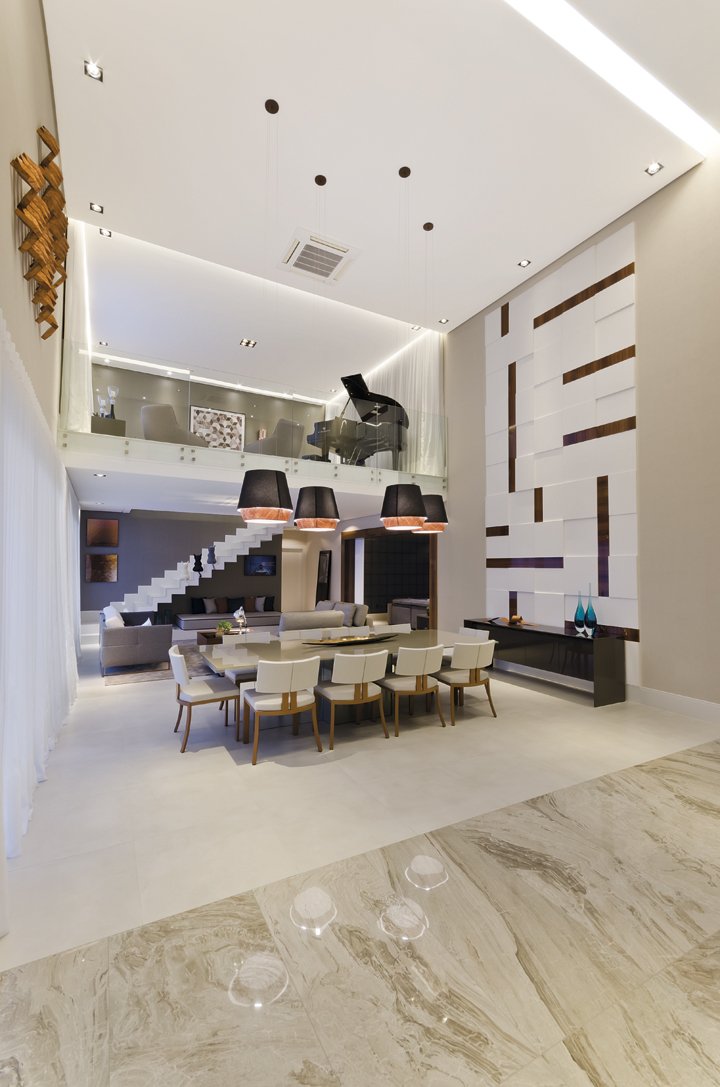 A varanda gourmet é integrada à cozinha e ao living, personalizado pelo imenso painel branco em MDF, desenhado pela arquiteta