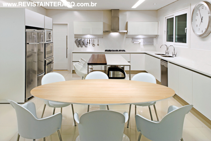 A proposta clean da cozinha soma armários brancos com bancada em Corian (Multipedras Mármores e Granitos) e detalhes em madeira clara