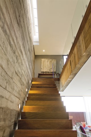 A leveza da escada com degraus em concreto e acabamento em madeira