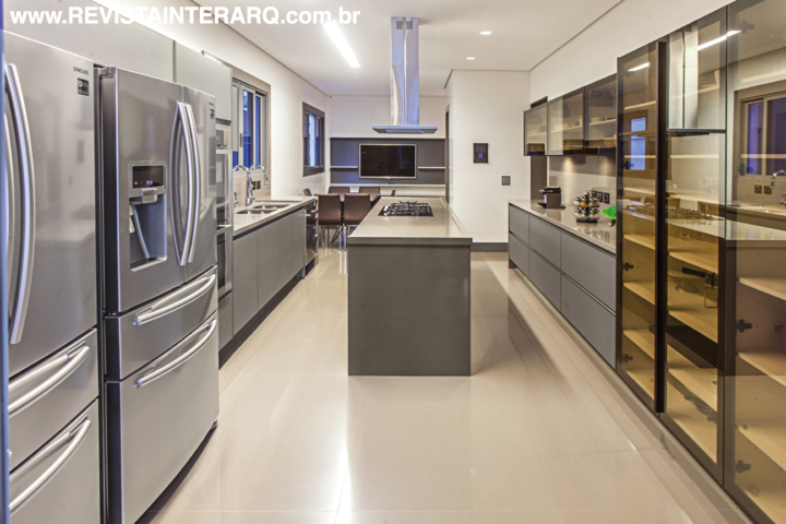 Portas de vidro bronze da Cinex (Abito) conferiram mais charme à cozinha com piso em porcelanato da Portobello Shop. Eletrodomésticos e coifa da Elettromec