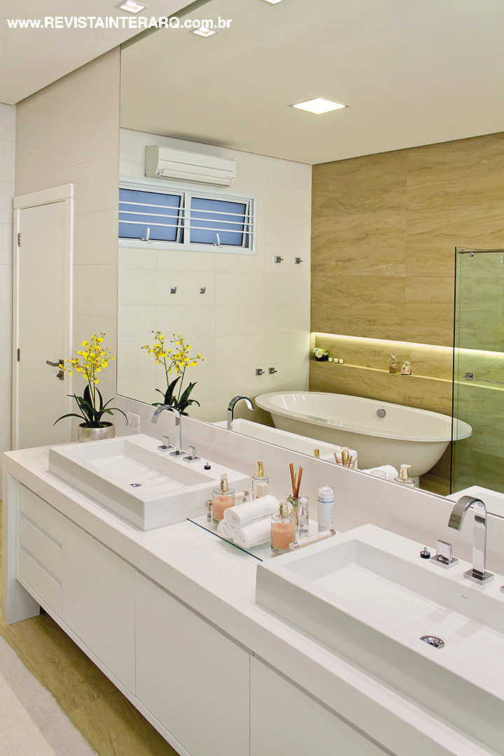 Na sala de banho, a bancada com cuba dupla (Casa dos Construtores) é em mármore Branco Prime. Móvel da Movelaria Polidoro