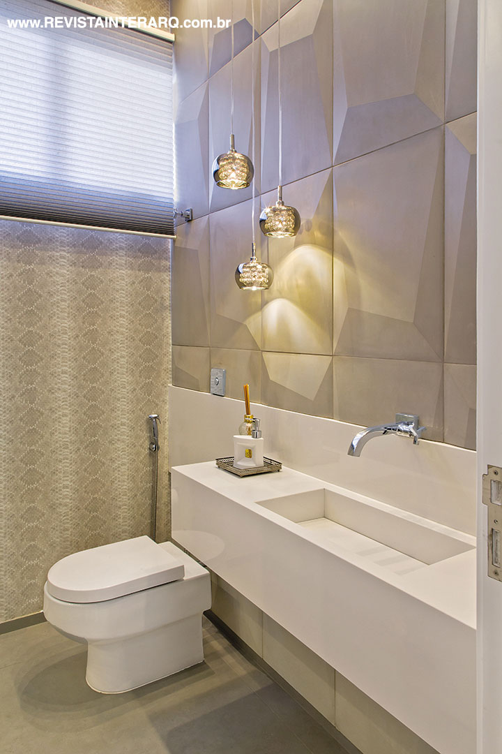 O lavabo mescla a suavidade da bancada em Silestone branco (Fran Mármore) com o revestimento cinza gelo e o papel de parede em texturas