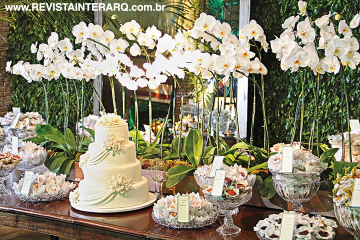 O conjunto de orquídeas brancas atraía os olhares para a mesa dos doces (Dora Vendramini) e do singelo bolo branco