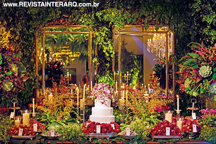 A mesa de doces (Dora Vendramini) parecia um jardim, forrada com flores, folhagens e grandes arranjos. Sobre o bolo de quatro andares (Doces & Afins), Daniella criou um arranjo com flores naturais, explorando as orquídeas denphales, catleyas e cymbidium