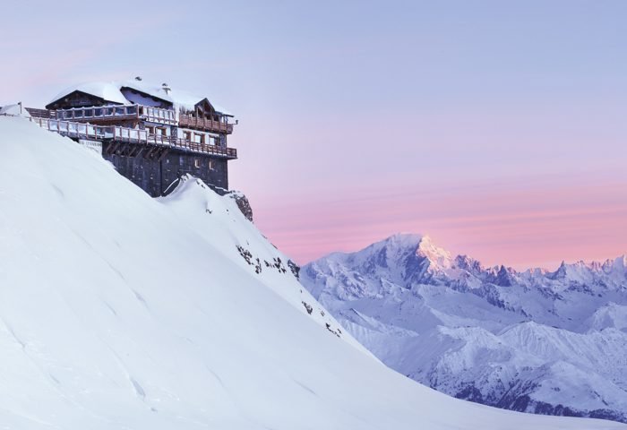 Belos tons de azul, rosa e lilás banham as montanhas cheias de neve dos Alpes Franceses, onde os visitantes podem desfrutar da vista em uns dos excelentes hóteis ao lado das pistas de esqui